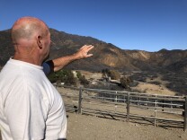 Butch Humphrey explains how the fire came over the ridge and toward his house.