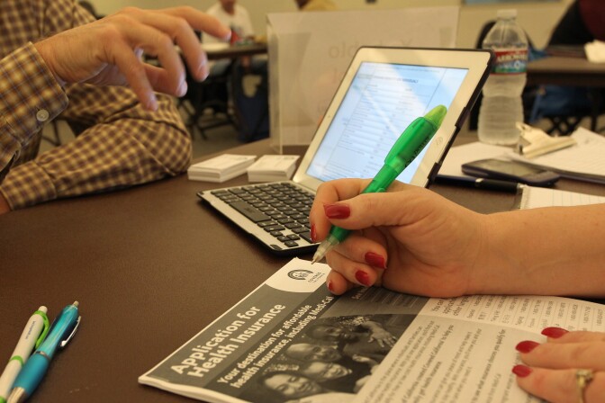 A healthcare reform specialist helps people select insurance plans at the free Affordable Care Act (ACA) Enrollment Fair at Pasadena City College on November 19, 2013 in Pasadena, California.