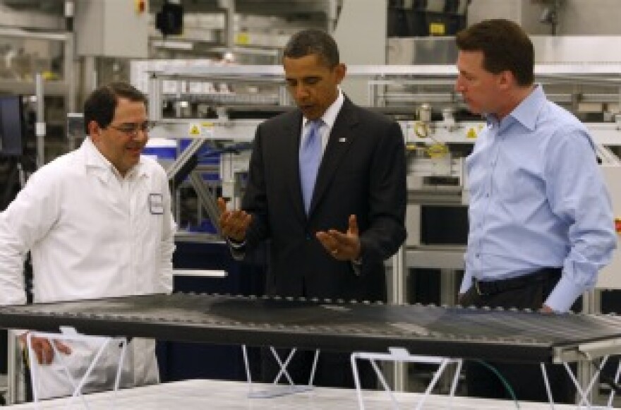 Ben Bierman (left) and Chris Gronet (right) explain solar technology to U.S. President Barack Obama on a tour of the Solyndra solar panel company May 26, 2010 in Fremont, California.