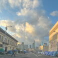 Makeshift tents line with both sides of a city street with tall skyscrapers visible in the background.