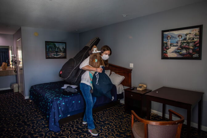 Julie Mariane gathers her belongings in a motel room provided to homeless people by the NGO St. Joseph Center, as  she gets ready to be transferred to a hotel room in Venice Beach, California on April 26, 2020. - Julie has been living in the street for one and a half years. The NGO St. Joseph Center is providing Hotel rooms to the homeless people at risk or infected with Covid-19, through Project Roomkey of the City of Los Angeles. (Photo by Apu GOMES / AFP) (Photo by APU GOMES/AFP via Getty Images)