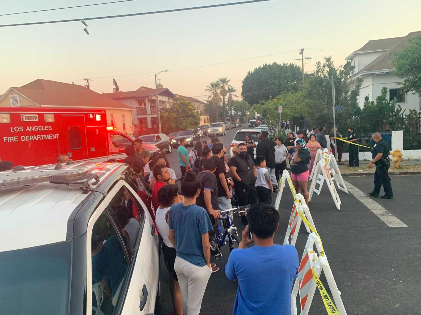 Crowd looks over firework detonation site on a blocked road in South LA.