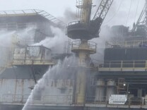 Smoke rises from an oil platform.