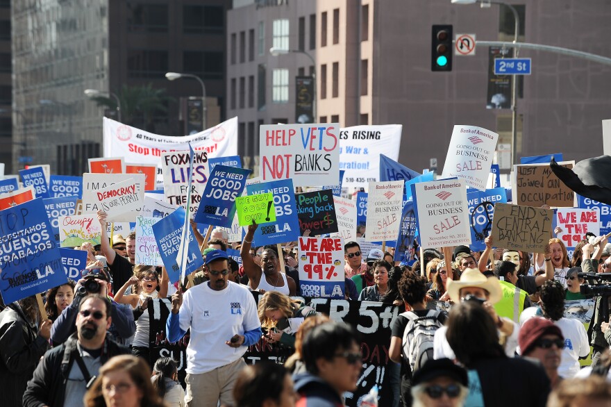 Occupy LA protestors march through the downtown Los Angeles financial district. Police Chief Charlie Beck announced Tuesday a timeline for closing the LA City Hall encampment.