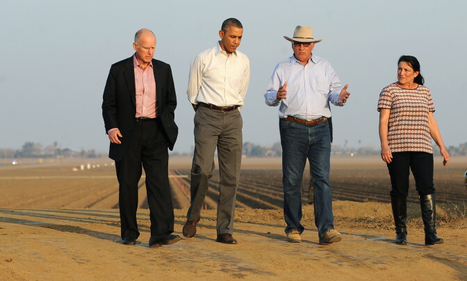 US President Barack Obama (2nd-L) walks with California Governor Jerry Brown (L), Joe and Maria Del Bosque (R) of Empresas Del Bosque farm, addressing California's drought situation Friday, Feburary 14, 2014 in Los Banos, CA.