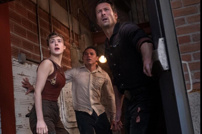 three people stand in an open doorway