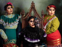 A drag reinterpretation of  the Frida Kahlo painting "The Three Fridas"; one is sitting in a dramatic gothic chair wearing a traditional Mexican black lace dress and heavy black make up; one on the right wears a gold and red long dress while the one on the left wears a green floral long dress.