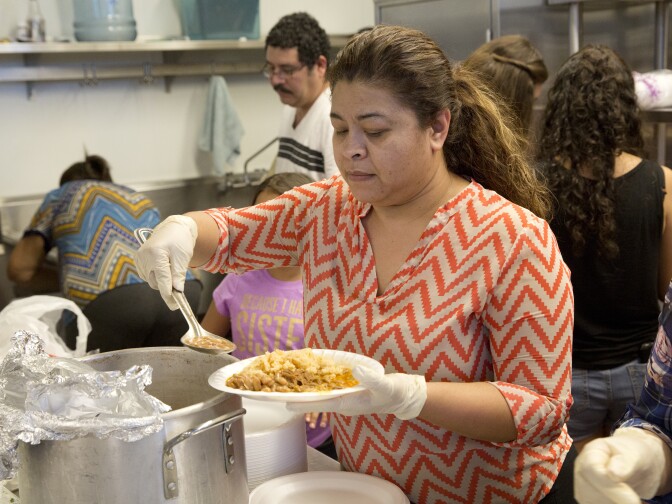 Ana Gallardo a volunteer with The Guadalupe Homeless Project serves up home made food for the homeless people at Proyecto Pastoral on July 13, 2016.