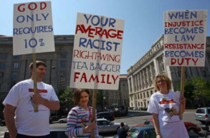 People hold signs during a Tea Party Protest in Freedom Plaza April 15, 2010 in Washington, DC. The event, titled the People's Tax Revolt, coincided with the day that American citizens are required to file their national income tax.