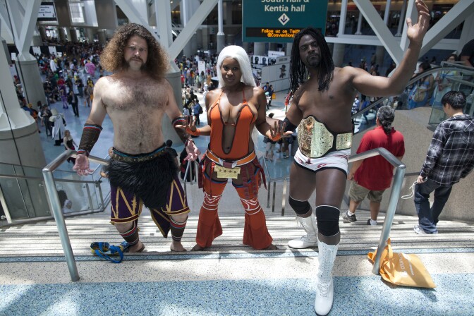 Kevin Booth, left, and Brittney Phillips are dressed as Meng Huo and Zhu Rong from the video game Dynasty Warriors 7 during the Anime Expo at the Los Angeles Convention Center. Aaron Wilson, right, came dressed as the WWE wrestler Booker T.