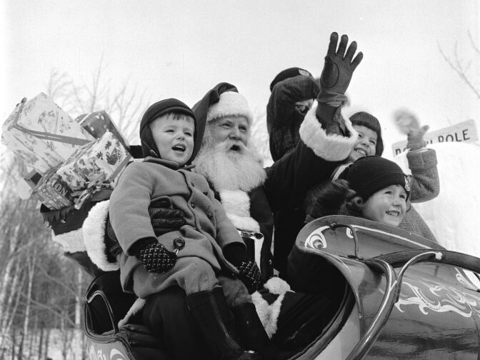 circa 1955:  Santa Claus treats young visitors to a sleigh ride at his  North Pole Workshop in the Adirondack Mountains of New York State.  (Photo by Orlando /Three Lions/Getty Images)