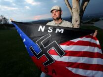 Jeff Hall holds a Neo Nazi flag while standing at Sycamore Highlands Park near his home in Riverside, Calif., on Friday, Oct. 22, 2010.