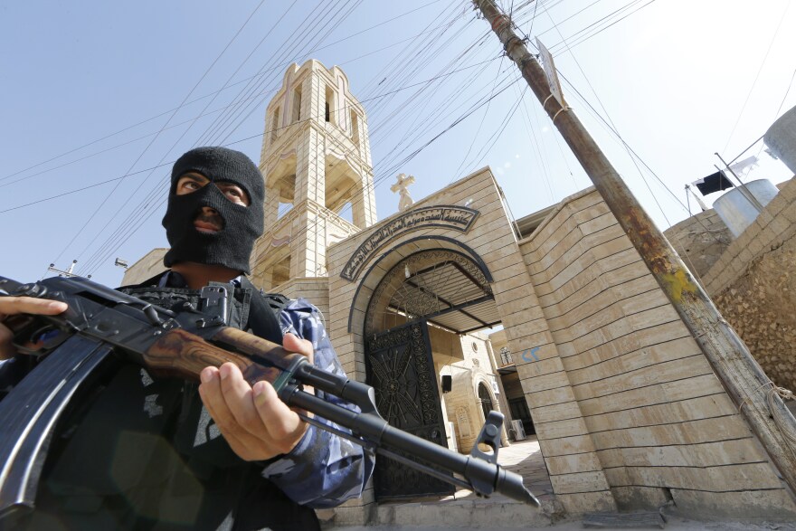 An Iraqi security officer stands guard outside the Church of the Virgin Mary in the northern town of Bartala, on June 15, 2012, east of the northern city of Mosul as some Iraqi security stayed in the town to protect the local churches and community.
