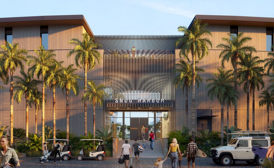 The sleek exterior of a building framed by palm trees and golf carts. Many people entering the building are carrying surf boards. 
