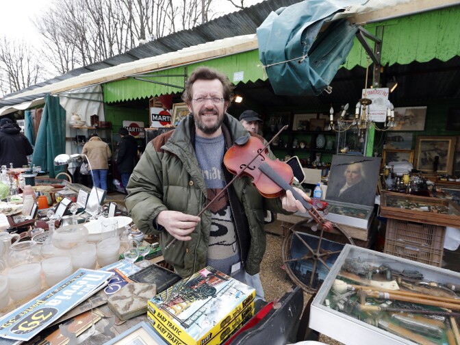 A man holds a violin on March 17, 2013 at the National Antiques and Ham Fair in the western Paris suburb of Chatou.