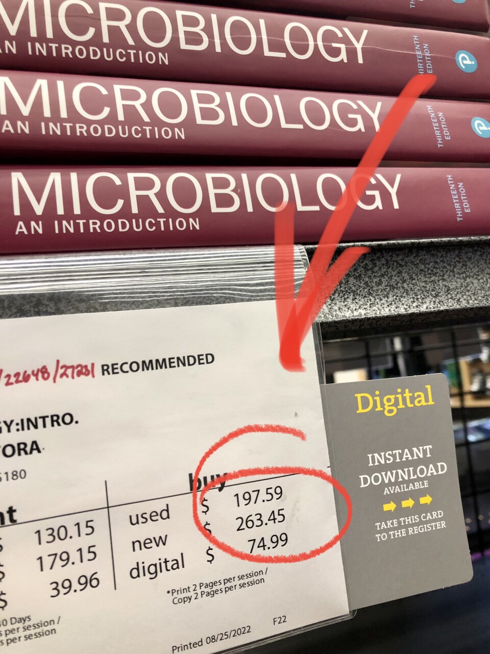 A microbiology college textbook on a stack at a bookstore is listed for $263 new.