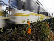 A Metro Expo line train passes dedication ceremonies for the Metro/LAX light rail transit line at Crenshaw and Exposition Boulevards in Los Angeles' Crenshaw district, Tuesday, Jan. 21, 2014. When completed the line will connect the Metro Exposition and the Green lines. a distance of just over eight miles. (AP Photo/Reed Saxon)