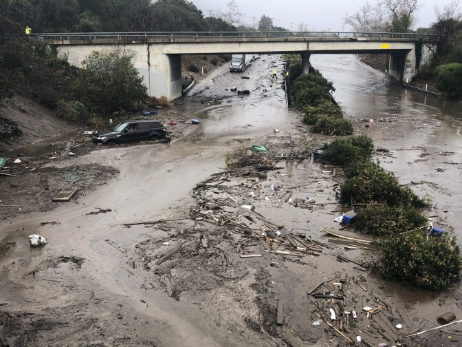 In this photo provided by Santa Barbara County Fire Department, U.S. Highway 101 at the Olive Mill Road overpass is flooded with runoff water from Montecito Creek in Montecito, Calif. on Tuesday, Jan. 9, 2018.