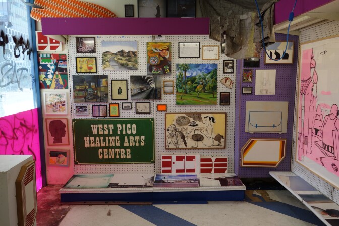 A nook of a discount store that has been covered with visual art of different mediums and styles.