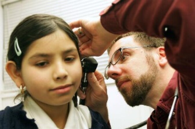 Fourth-grader Arylu Paniagua, 9, receives an ear exam from Dr. Michael Paul during a physical in the Loyola Pediatric Mobile Health Unit, parked outside Columbus West Elementary School, February 22, 2005 in Cicero, Illinois.