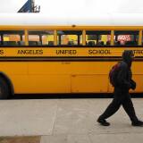 A student on his way to school walks past a Los Angeles Unified School District (LAUSD) school, in Los Angeles, California on February 13, 2009. California Governor Arnold Schwarzenegger has threatened to send layoff warnings to at least 20,000 state workers unless a budget agreement is reached Friday.  AFP PHOTO/ ROBYN BECK (Photo credit should read ROBYN BECK/AFP/Getty Images)