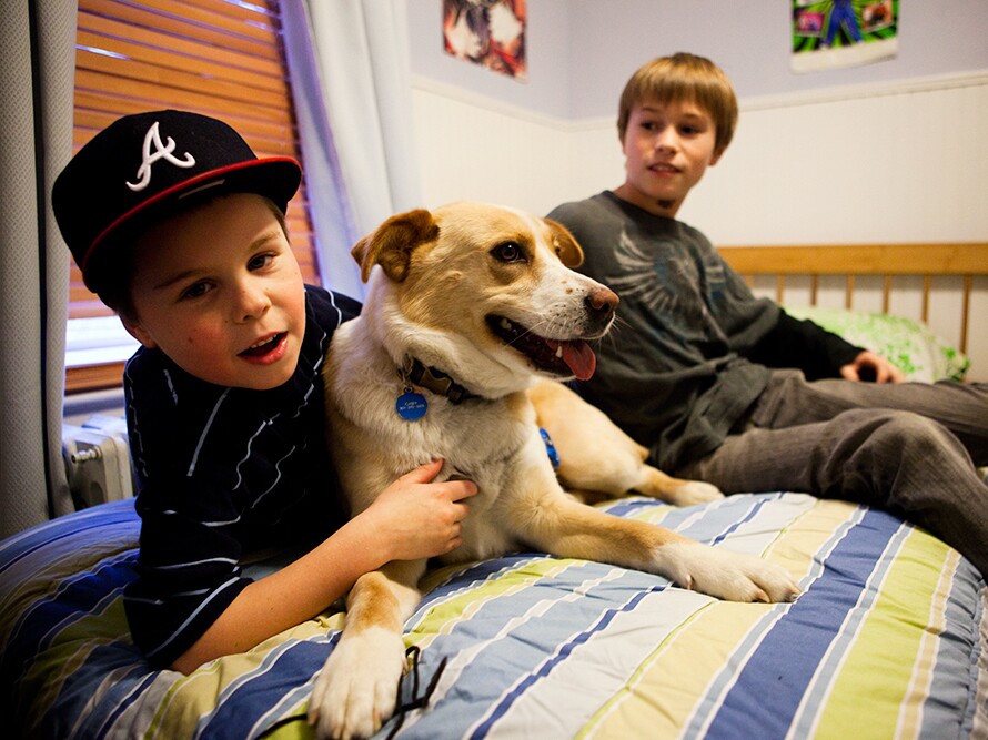 Tyler Scorza lounges on his bed with his older brother, Joe, and their dog, Casey.