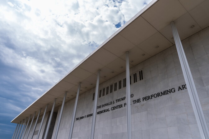 A cream colored building with signage that reads "The Donald J Trump and The John F. Kennedy Center For The Performing Arts."