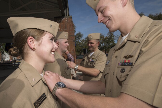 KINGS BAY, GA - DECEMBER 5:  In this handout photo provided by the U.S. Navy, Lt. j.g. Luke Leveque, assigned to the Gold crew of the ballistic missile submarine USS Maryland (SSBN 738), pins the submarine officer warfare device on his wife, Lt. j.g. Marquette Leveque, assigned to the Gold crew of the ballistic missile submarine USS Wyoming (SSBN 742), at Naval Submarine Base Kings Bay on December 5, 2012 in Kings Bay, Georgia. Leveque is one of three Sailors to become the first female unrestricted line officers to qualify in submarines. (Photo by Mass Communication Specialist 1st Class James Kimber/U.S. Navy via Getty Images)