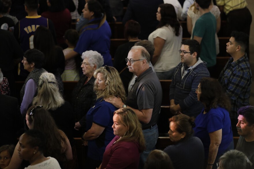 People attend a prayer service to honor the shooting victims at North Park Elementary School, Monday, April 10, 2017, in San Bernardino, Calif. A man walked into his estranged wife's elementary school classroom in San Bernardino and opened deadly fire. (AP Photo/Jae C. Hong)