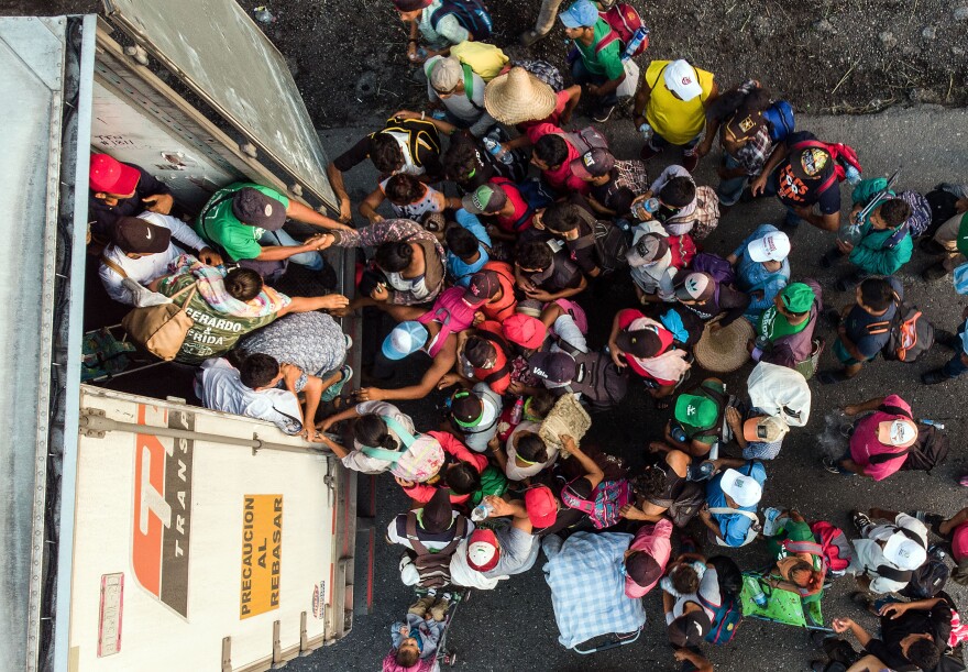 TOPSHOT - Honduran migrants taking part in a caravan heading to the US, get on a truck, near Pijijiapan, southern Mexico on October 26, 2018. - The Pentagon is expected to deploy about 800 troops to the US-Mexico border, two US officials told AFP on Thursday, after President Donald Trump said the military would help tackle a "national emergency" and called on a caravan of US-bound migrants to turn around. (Photo by Guillermo Arias / AFP)        (Photo credit should read GUILLERMO ARIAS/AFP/Getty Images)