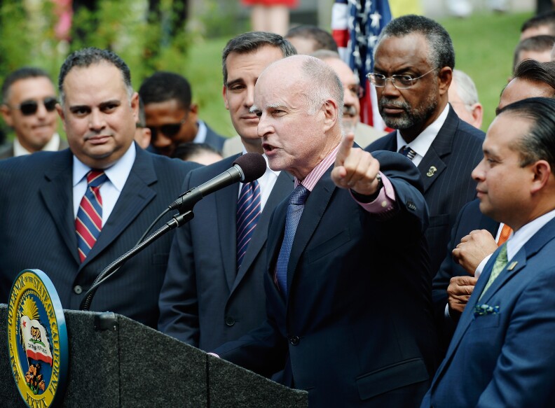 California Governor Jerry Brown speaks before signing bill AB60 on the steps of Los Angeles City Hall  October 3, 2013 in Los Angeles, California. California Assembly Bill 60 also known as the Safe and Responsible Driver Act allows illegal immigrants to receive a permit to legally drive in California.   