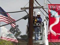 In this March 6, 2012 photo, an AT&T technician works on fiber optic cables used for the expansion of AT&T U-verse Internet service in the Chinatown neighborhood in Los Angeles. Unionized AT&T West workers rejected their contract Thursday. It’s possible the workers may strike Saturday. 