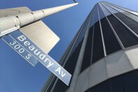 A street sign reading "300 S Beaudry Av" on a light pole in front of a massive office building