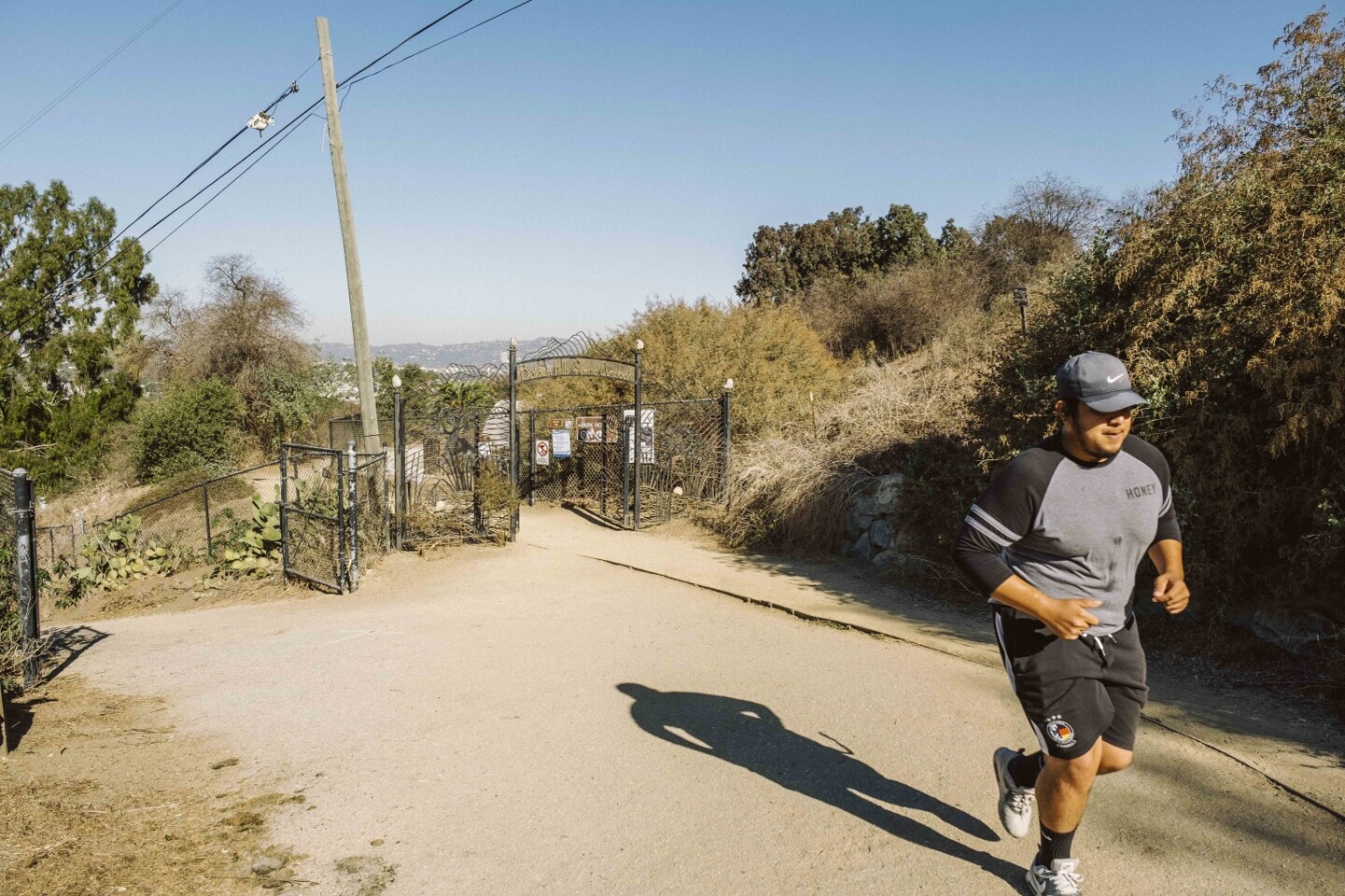 A runner passes into Culver City Park from the Baldwin Hills Overlook portion of the Park to Playa Trail.