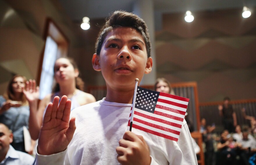 LOS ANGELES, CA - SEPTEMBER 14:  New U.S. citizen Davies Garcia, 11, originally from Mexico, holds an American flag during a naturalization ceremony conducted by U.S. Citizenship and Immigration Services (USCIS), on September 14, 2018 in Los Angeles, California. USCIS presented citizenship papers at the L.A. Public Library to around 50 young people who obtained their citizenship via their parents. Some of the young people became citizens once their immigrant parents became citizens while others were adopted by citizens of the U.S. The ceremony was part of annual Constitution Week and Citizenship Day celebrations conducted by USCIS.  (Photo by Mario Tama/Getty Images)