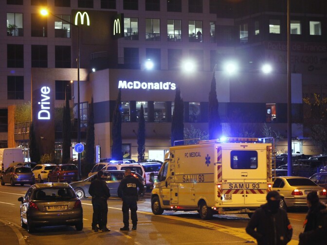 Police and rescuers gather in front of a fast-food drive erstaurant outside the Stade de France stadium in Saint-Denis, north of Paris, late on November 13, 2015, after a series of gun attacks occurred across Paris as well as explosions outside the national stadium where France was hosting Germany. A number of people were killed and others injured in a series of gun attacks across Paris, as well as explosions outside the national stadium where France was hosting Germany.    AFP PHOTO / FRANCOIS GUILLOT        (Photo credit should read FRANCOIS GUILLOT/AFP/Getty Images)