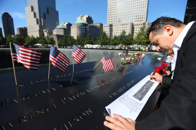 NEW YORK - SEPTEMBER 11:   Clever Rivas makes a rubbing of his brother Moises N. Rivas' engraved name during memorial ceremonies for the eleventh anniversary of the terrorist attacks on lower Manhattan at the World Trade Center site September 11, 2012 in New York City. New York City and the nation are commemorating the eleventh anniversary of the September 11, 2001 attacks which resulted in the deaths of nearly 3,000 people after two hijacked planes crashed into the World Trade Center, one into the Pentagon in Arlington, Virginia and one crash landed in Shanksville, Pennsylvania. (Photo by Chang W. Lee-Pool/Getty Images)