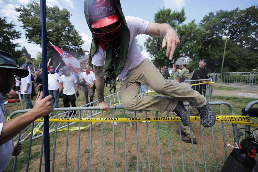 CHARLOTTESVILLE, VA - AUGUST 12:  White nationalists, neo-Nazis and members of the "alt-right" leap over barricades inside Lee Park during the "Unite the Right" rally August 12, 2017 in Charlottesville, Virginia. After clashes with anti-fascist protesters and police the rally was declared an unlawful gathering and people were forced out of Lee Park, where a statue of Confederate General Robert E. Lee is slated to be removed.  (Photo by Chip Somodevilla/Getty Images)