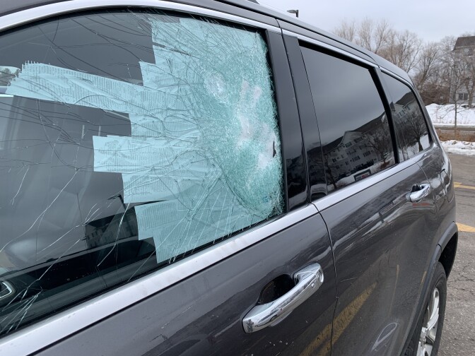A shattered car window is taped up.