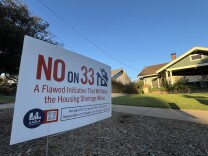 A "No on 33" sign is planted in front of a craftsman home.