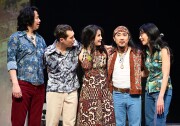 A group of three men and two women dressed in a colorful, busily-patterned shirts and jeans. 