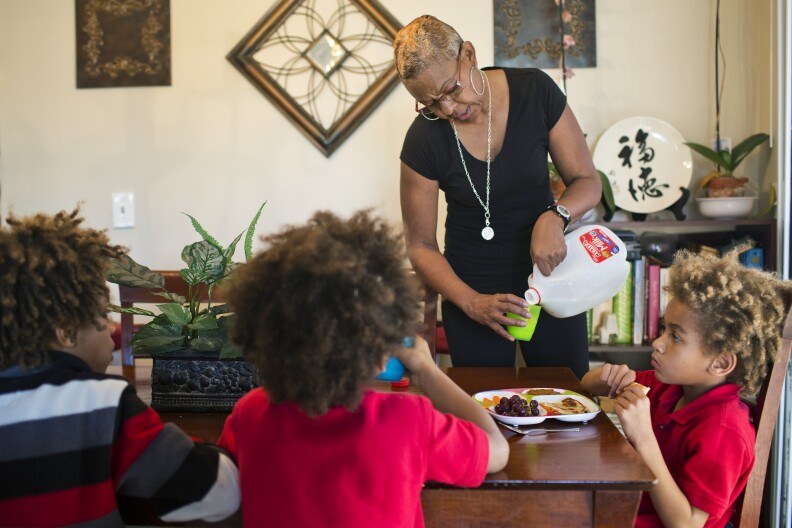 Home-based care provider Tonia McMillian makes a meal for brothers Jason, 8, Jayden, 7, and Skylar, 6.