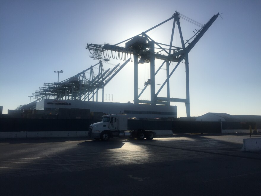 A truck heads into the APM Terminal at the Port of Los Angeles as the sun begins to set