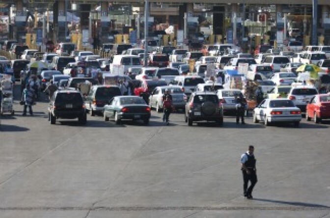 A member of the US Border Patrol walks behind the line of cars at the San Ysidro gate at the border between Mexico and United State in Tijuana, Mexico.