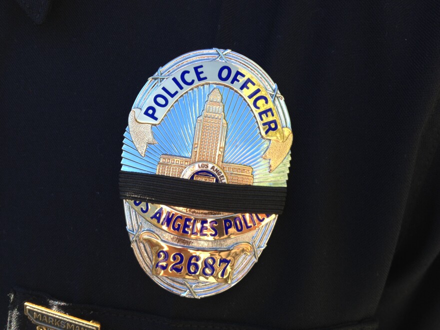LAPD officers are wearing a black band over their badge to mourn the murdered New York City police officers.