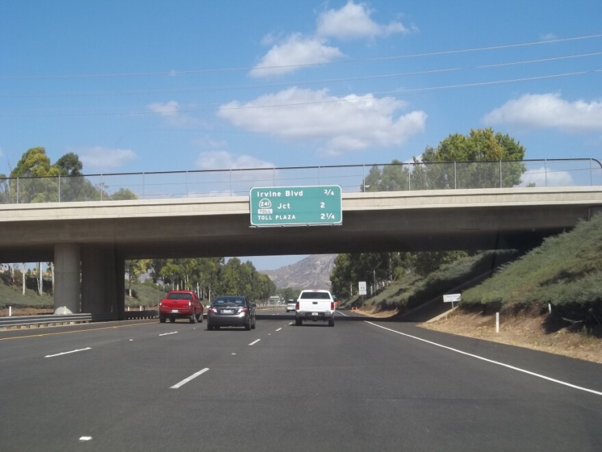 Photo shows northbound California State Route 133 and sign stating distances to Irvine Boulevard, Route 241 Toll and Toll Plaza.