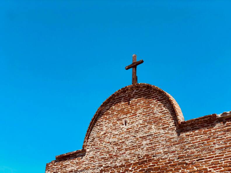 a cross on top of a brick building