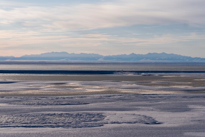 Frozen tundra with mountains in the distance
