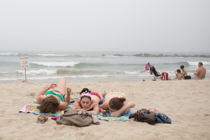 Girls take a nap at Venice Beach on June 27th, 2013. Temperatures at Venice Beach will be cooler than inland areas in Los Angeles this weekend.