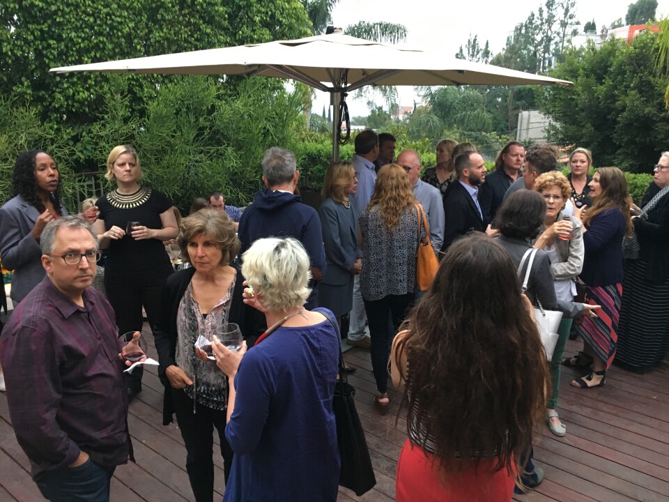 Members of Indivisible 2.9 mingle with celebrities on the deck of a home in the Hollywood Hills.